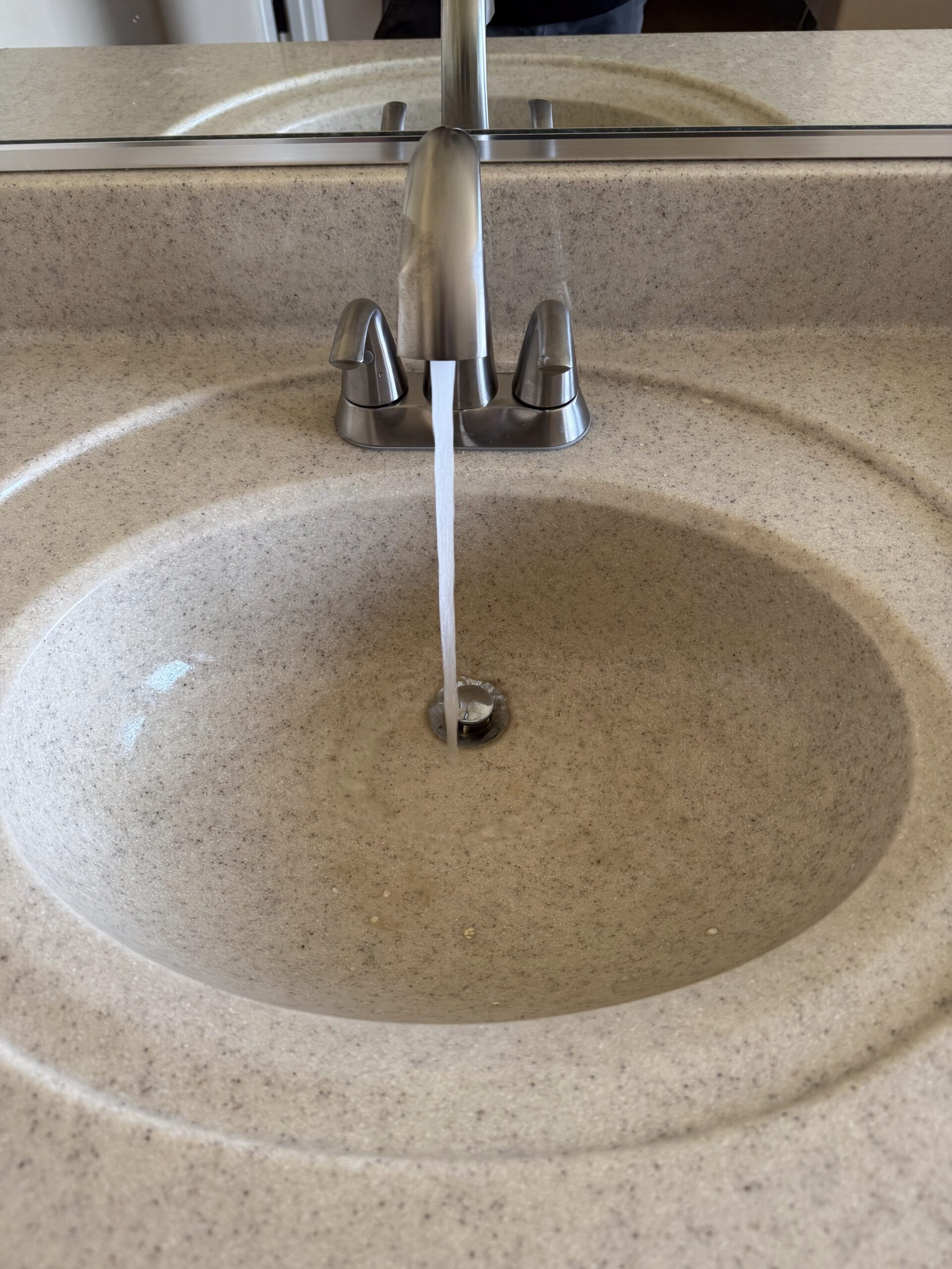 Faucet with running water over a sink, illustrating plumbing services provided by Edge Plumbing in Peoria, AZ.