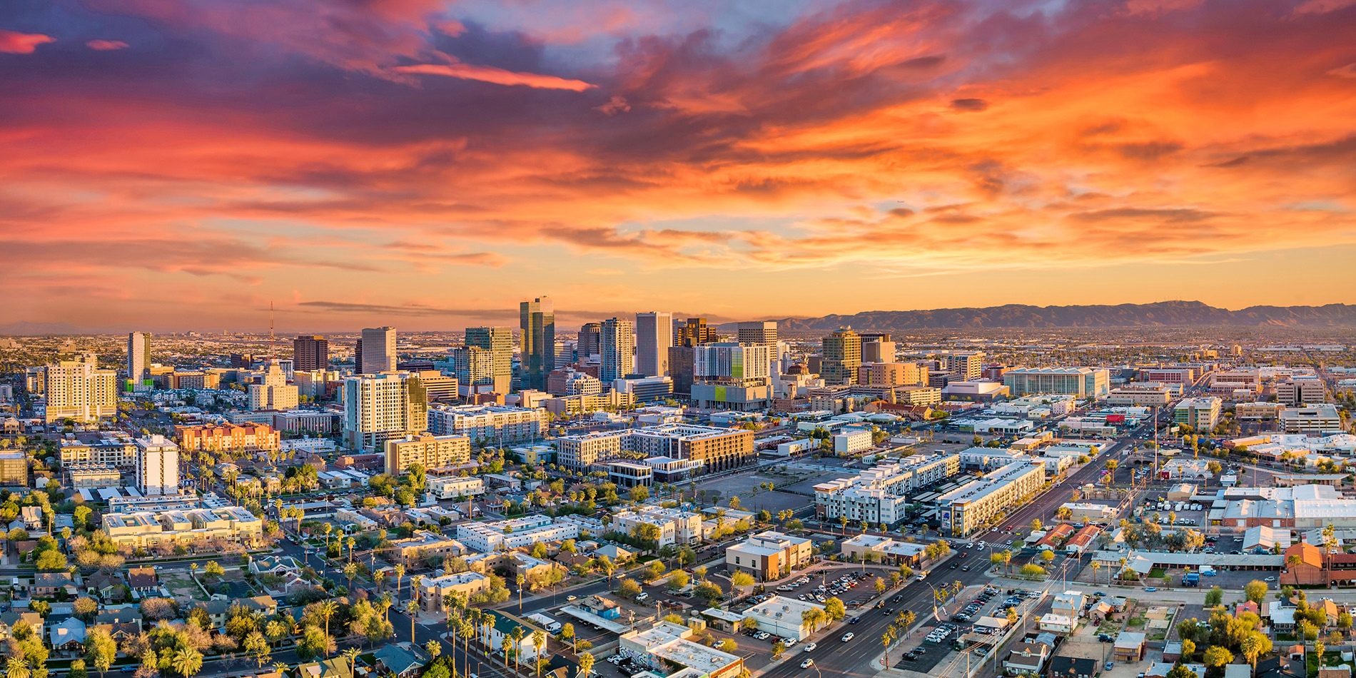 Phoenix cityscape at sunset, showcasing urban buildings and vibrant sky, relevant for plumbing services in the Phoenix metro area.