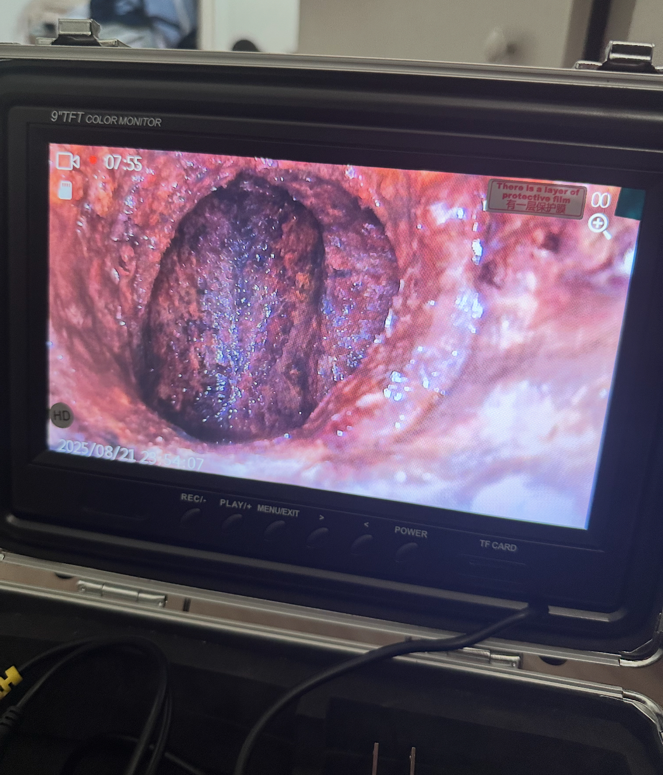 Camera monitor displaying a close-up view of a drainage pipe interior, highlighting debris buildup, relevant to plumbing camera inspections.