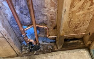 Copper plumbing pipes installed in a wall, showing potential low water pressure solutions for homeowners in Surprise, AZ.