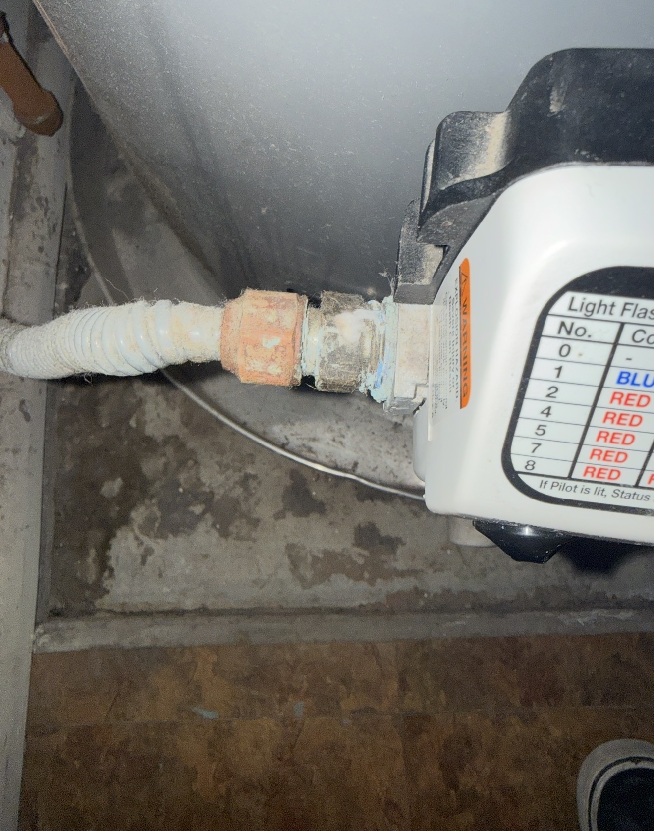 Tankless water heater control panel with warning labels and connection, showcasing plumbing details relevant to installation and repair services in Surprise, AZ.